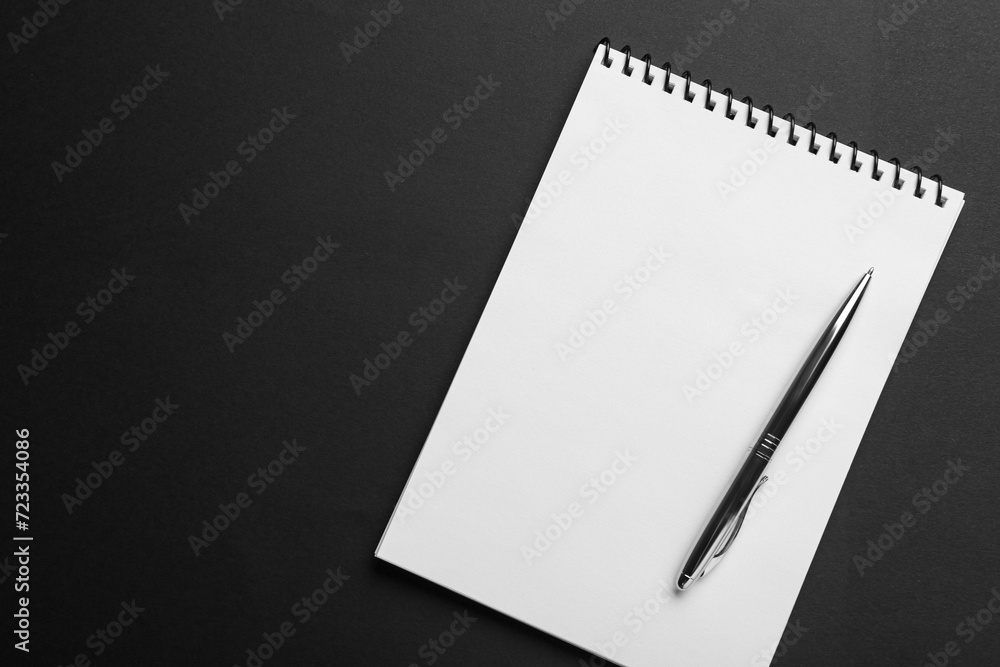 Notebook and pen on black background, top view. Space for text Notebook and pen on black background, top view. Space for text