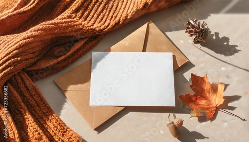 blank paper card mock up envelope brown fall leaves orange knitted textile on neutral beige background with aesthetic sun light shadowautumn business branding template wedding invitation design photo