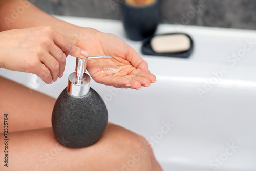 Closeup of woman washing hands with soap in bathroom at home. 