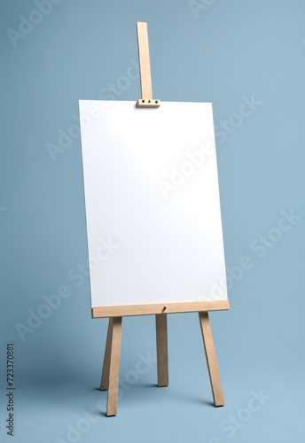 easel with blank canvas in front of a grey blue wall