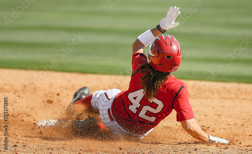 An American softball player slides into base during game action. 