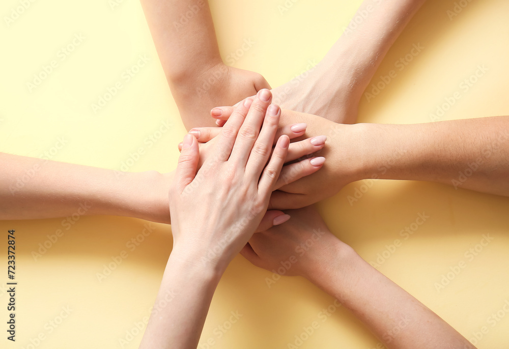 Obraz premium People putting hands together on beige background. Inclusion concept