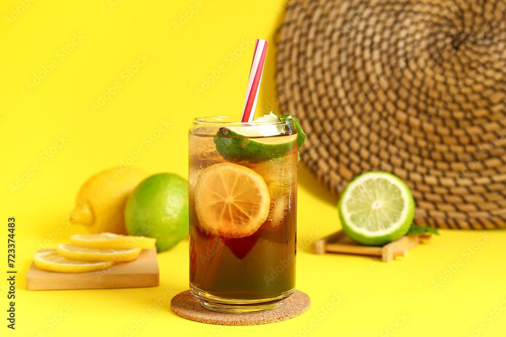 Fototapeta premium Glass of cold Long Island iced tea on yellow background