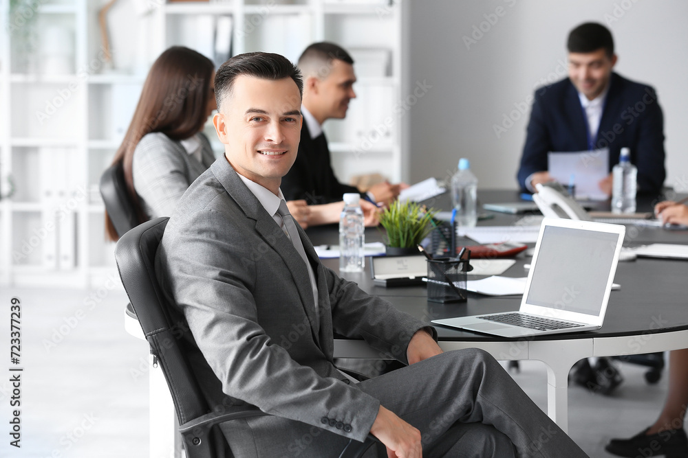Businessman negotiating at table in conference hall Businessman negotiating at table in conference hall
