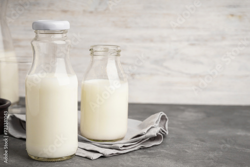 Milk in jar and glass on the grey background.