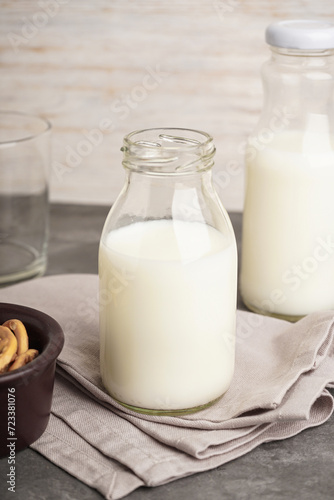 Milk in jar and glass on the grey background.