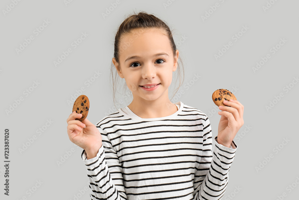 Cute little girl with cookies on grey background Cute little girl with cookies on grey background