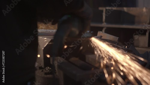 Sparks during pipe grinding at the factory by a worker