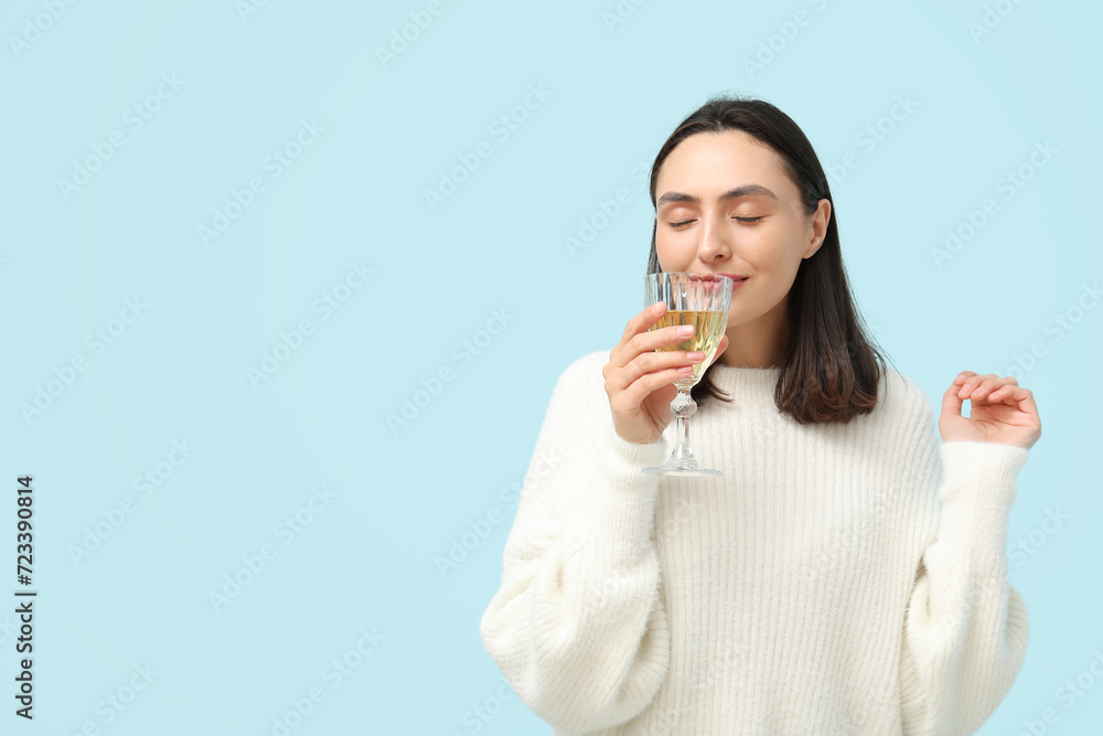 Beautiful young woman with glass of white wine on blue background Beautiful young woman with glass of white wine on blue background