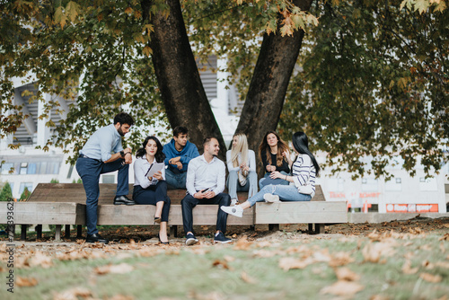 Young students collaborate, discuss subjects, prepare exams, work on a university project, achieving goals and better results as they study together in a park.
