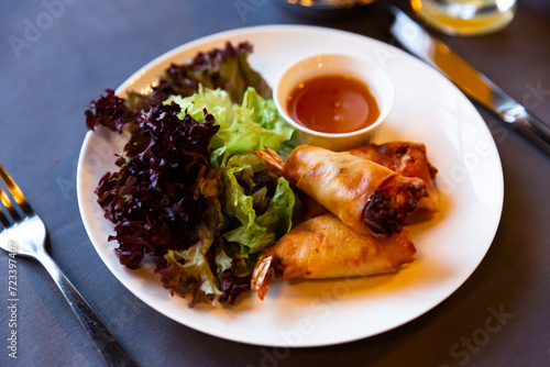 Crispy spring rolls with shrimps served with lettuce mix and sweet and sour sauce. Popular Thai appetizer