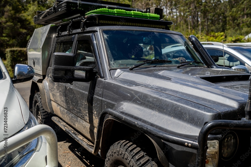 Fototapeta premium Camper trailer connected to a white car. SUV pulling a camper trailer with safety chains and wiring corrector