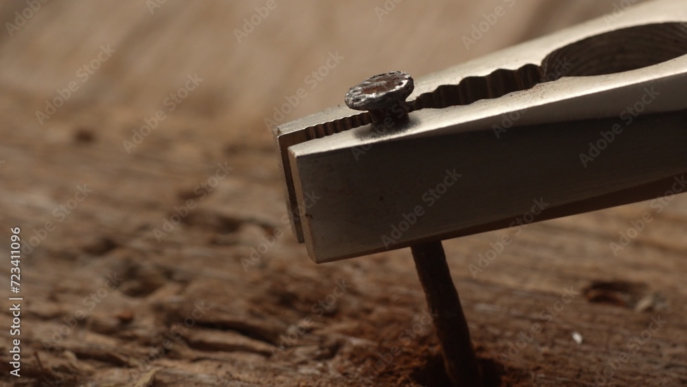 Pliers Removing Nail from Old Wood. Close-up, shallow dof.