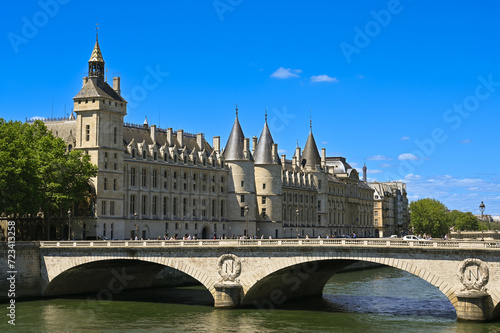 Nice shot of the Conciergerie Castle and the Bridge of Change (Pont au Change) over the Seine. Passage of pedestrians and cars on the bridge, beautiful summer day. © Massimo Parisi