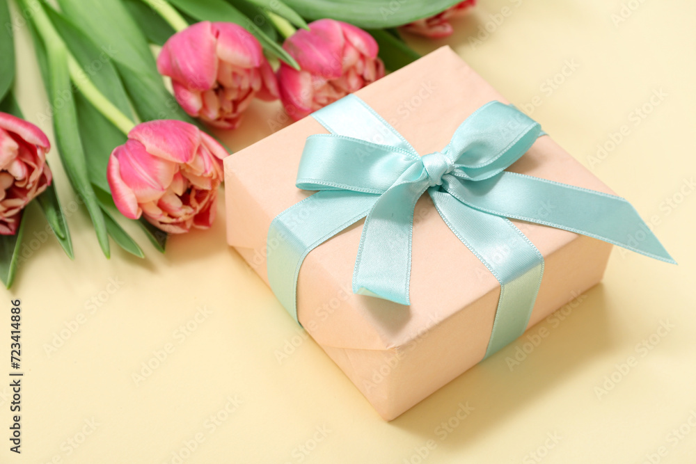 Gift box and bouquet of beautiful tulips on yellow background. International Women's Day Gift box and bouquet of beautiful tulips on yellow background. International Women's Day