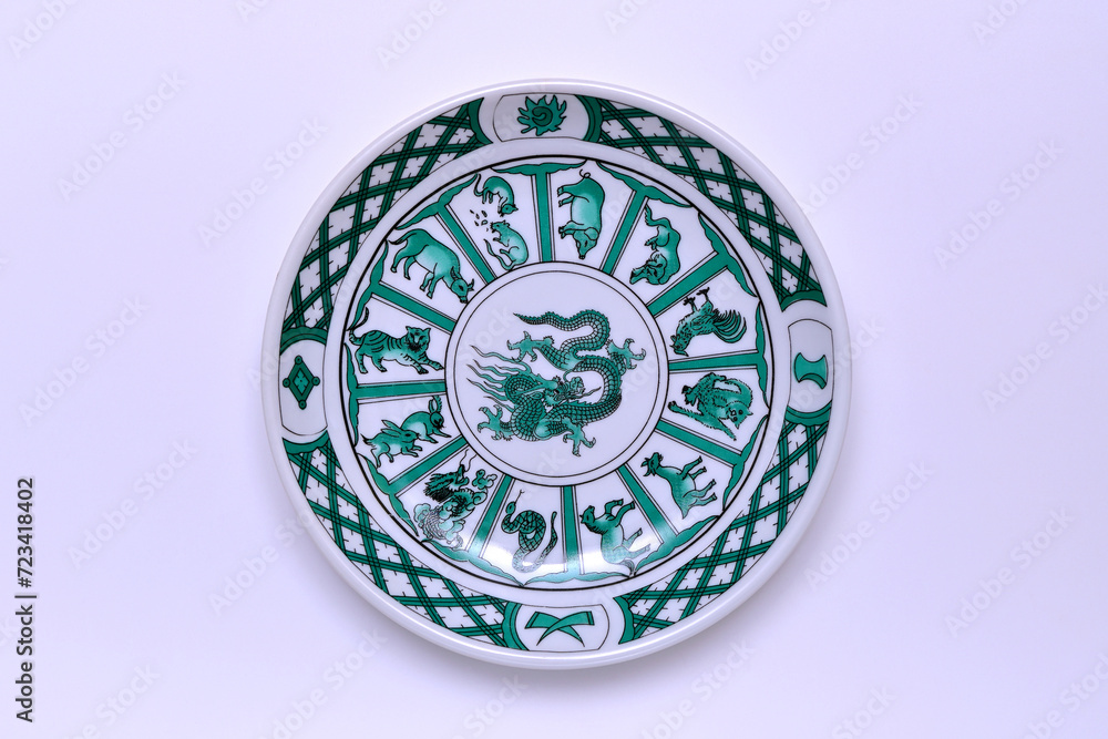 vintage plate with a dragon and other signs of the Chinese horoscope on a white background