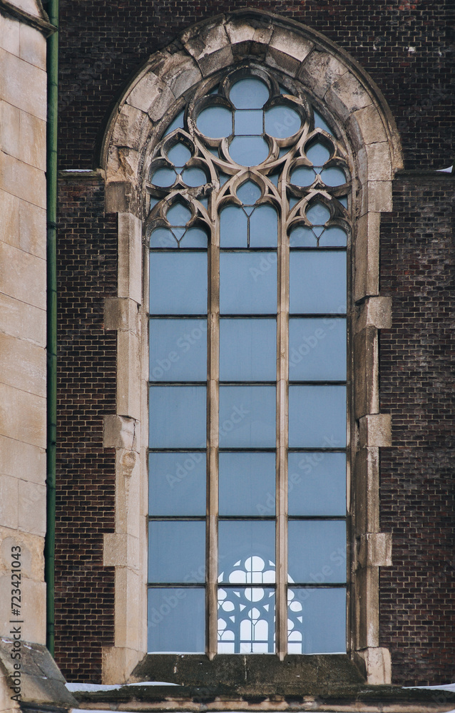 Elongated vintage vertical window on the facade of the building. Baroque and Gothic architecture. Church of St. Olga and Elizabeth. Lviv, Ukraine.