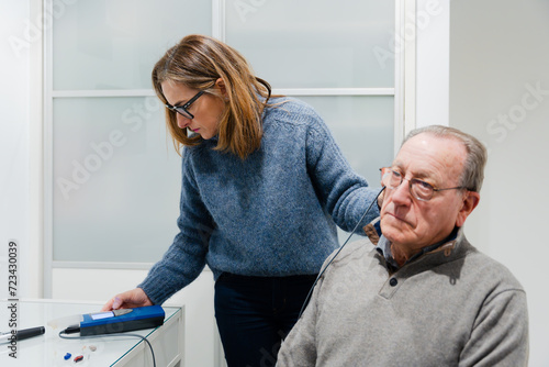Audiology doctor checking hearing to patient using a tympanometer. photo