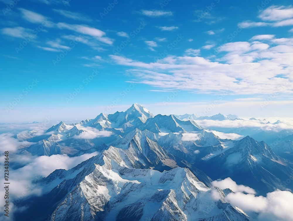 Stunning snow-covered mountain range with a majestic peak standing tall against a clear blue sky.