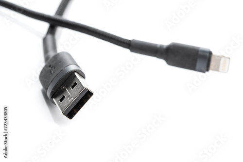 Black USB braided cable - Lightning isolated on a white background, close -up. (selective focus)