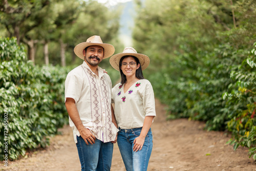 Fotografi farmers smile happily in the middle of the coffee field.