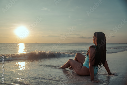 Mujer latina observando el ocaso en una playa de la isla de margarita en Venezuela photo