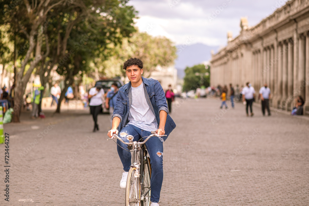 Portrait of a handsome Latin young man riding a bicycle at the Guatemala City park.