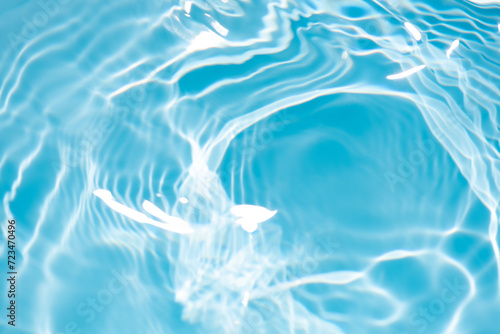 Water surface. Bluewater waves on the surface ripples blurred. Defocus blurred transparent blue colored clear calm water surface texture with splash and bubbles. Water waves with shining pattern.