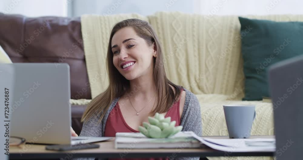 Happy, laptop and woman on video call in living room waving hello for greeting communication. Smile, technology and young female person from Canada on virtual conversation with computer at home. Happy, laptop and woman on video call in living room waving hello for greeting communication. Smile, technology and young female person from Canada on virtual conversation with computer at home.