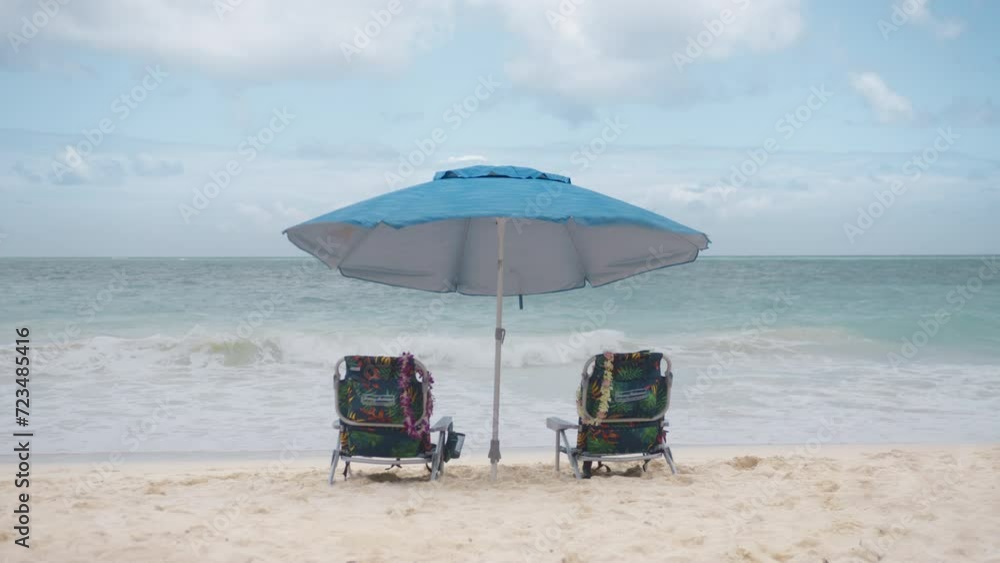 Colorful beach chairs and sun umbrella near scenic blue ocean. Summer vacation and vacation concept for tourism. Inspiring tropical landscape 4K. Beautiful beach Waimanalo, Oahu island, Hawaii USA