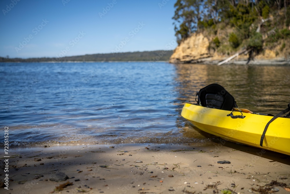 yellow canoe and kayak on a sandy beach in Australia in summer. kayaking on the sea in tasmania yellow canoe and kayak on a sandy beach in Australia in summer. kayaking on the sea in tasmania