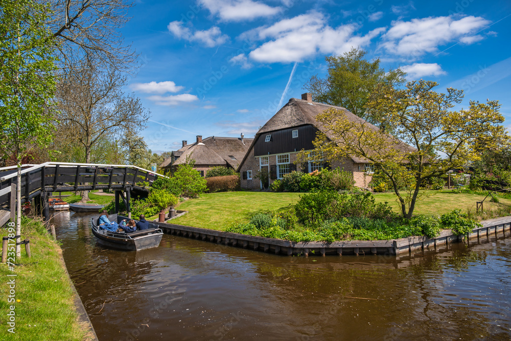 Giethoorn, Netherlands - May 4, 2023 : tourists navigating canal of Giethoorn village in boats