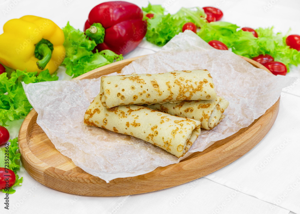 Homemade pancakes with filling on a wooden board Homemade pancakes with filling on a wooden board