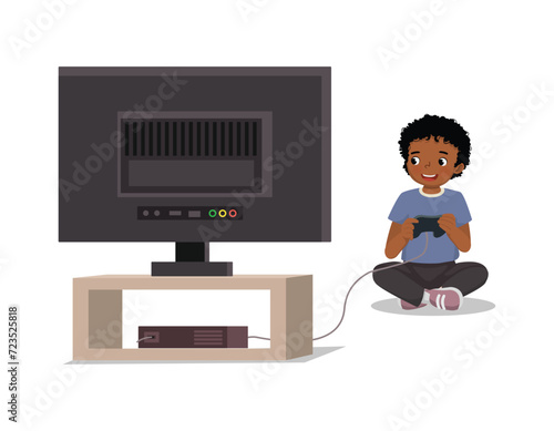 Cute little African boy playing video game