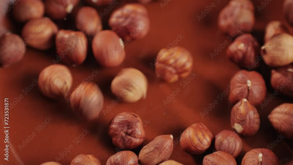 Peeled hazelnut falling down on red plate close-up macro. Hazelnuts without shell. Product rich in minerals and vitamins. Healthy snacks. Peeled hazelnut falling down on red plate close-up macro. Hazelnuts without shell. Product rich in minerals and vitamins. Healthy snacks.