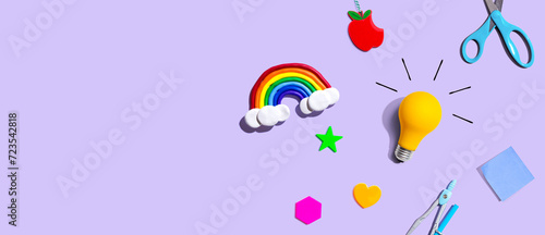 Idea light bulb with a rainbow and school supplies overhead view - flat lay