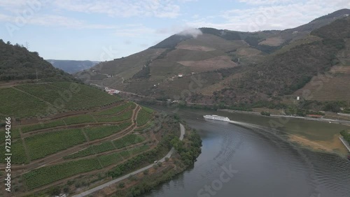 Aerial view of the wine town of Pinhão Portugal , Drone moving to the right over the river Douro showing the vines plantations and a tourist ship going down the river.