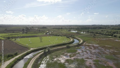 Aerial view of Ria de Aveiro in Estarreja. Drone moving forward over the flooded fields of the Ria. Blue sky and some clouds on the background. photo