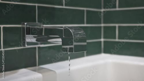 Extreme slow motion of a faucet being turned off, the flow in center frame. photo