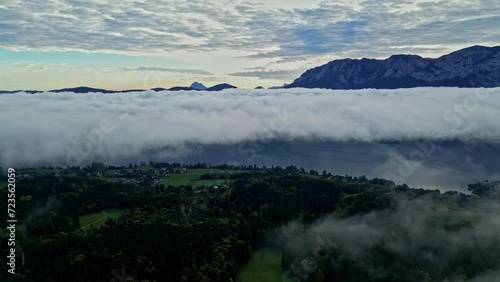 Massive cloud inversion above alpine countryside, mountain peaks above. photo