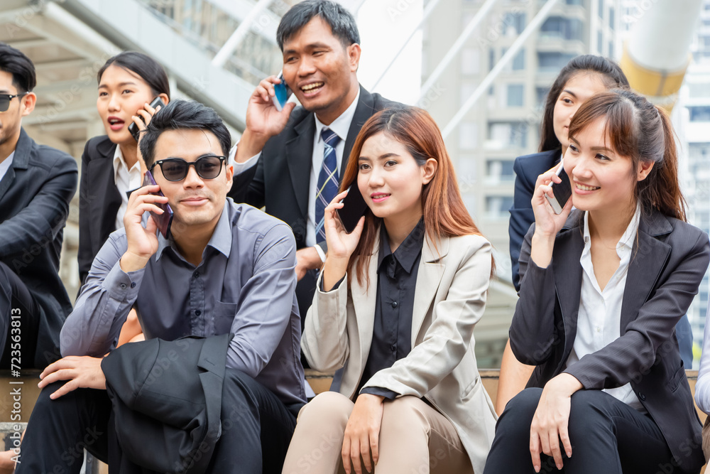 Young Asian business team discussing in the morning, Young businesspeople sitting on stairs with friends, Business people meeting and sharing ideas Young Asian business team discussing in the morning, Young businesspeople sitting on stairs with friends, Business people meeting and sharing ideas