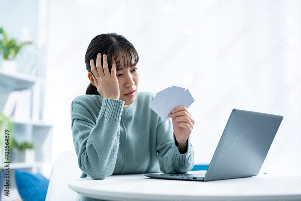 クレジットカードで悩む女性 クレジットカードで悩む女性