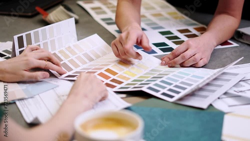 Close up hand choosing color from color sample swatch. The designer works with the customer and recommends the colors of decorative coatings.