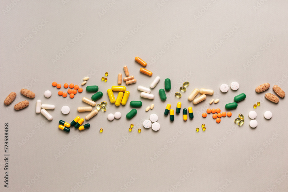 Colored and different shaped pills, meds, capsules, tablets, vitamins, minerals and food supplements on light grey background top view. Colored and different shaped pills, meds, capsules, tablets, vitamins, minerals and food supplements on light grey background top view.