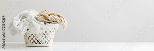 White basket with freshly cleaned laundry on white background. Spring cleaning and housekeeping concept. Banner for clinning service, dry cleaning, laundry with copy space. Template design for ads