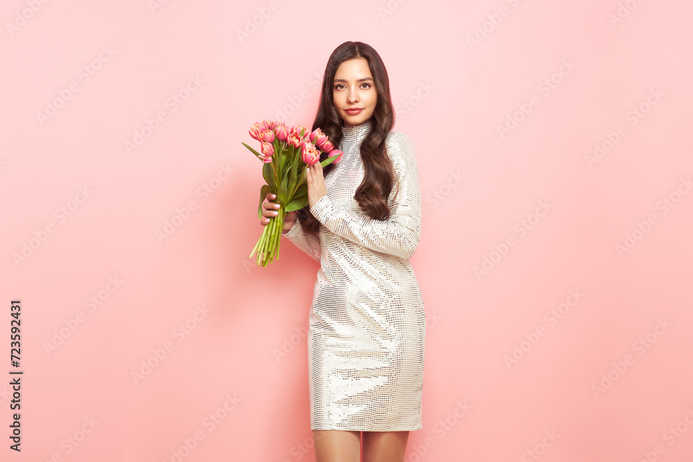 Happy beauty woman with pink tulip bouquet on light pink background. 8th of March celebration Happy beauty woman with pink tulip bouquet on light pink background. 8th of March celebration