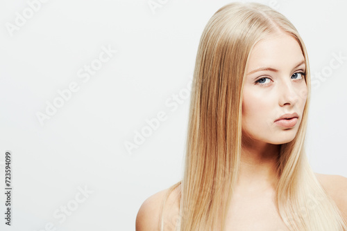 Portrait, model and confident or cosmetic in studio, skincare glow and cosmetology of facial treatment. Young woman, face and shine in self care or blonde hair and organic make up by white background