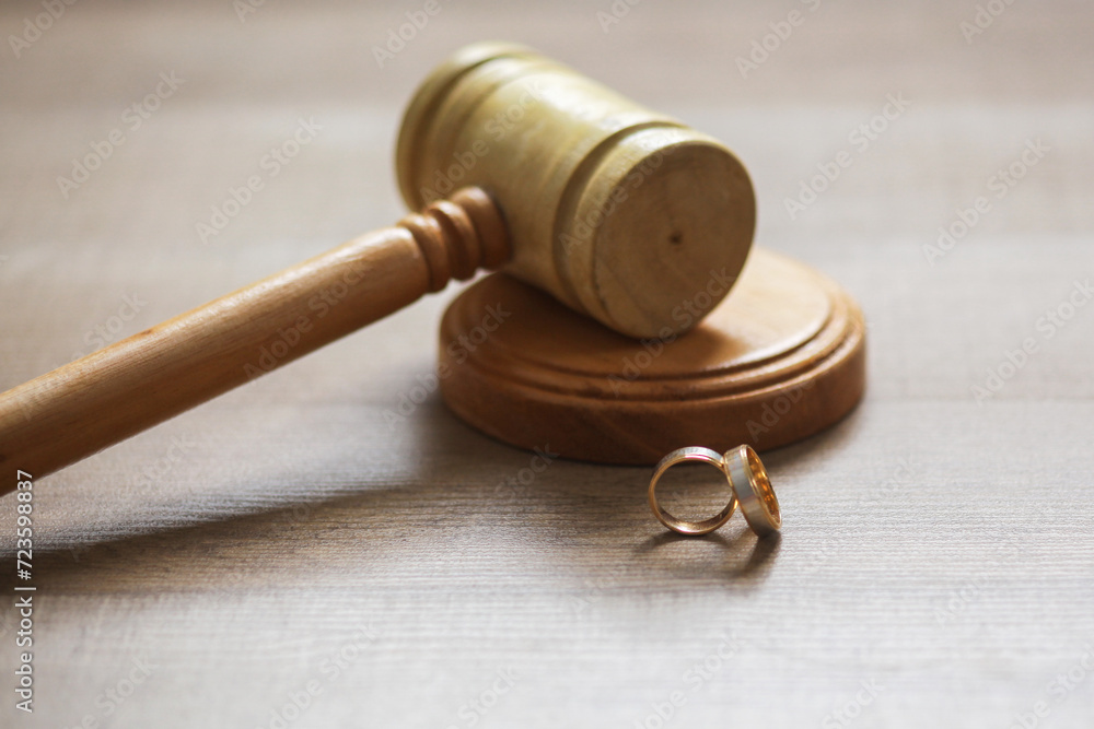 Marital divorce law concept. Judge gavel, wedding rings on pedestal on wooden background. Marital divorce law concept. Judge gavel, wedding rings on pedestal on wooden background.