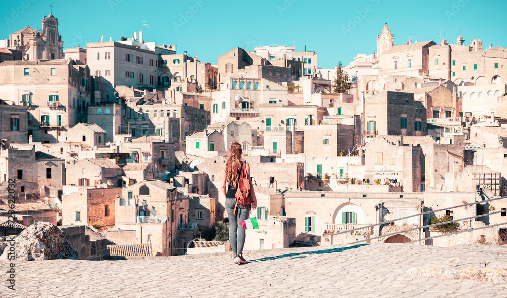 Young female tourist with Italian flag visiting city of Matera in Italy