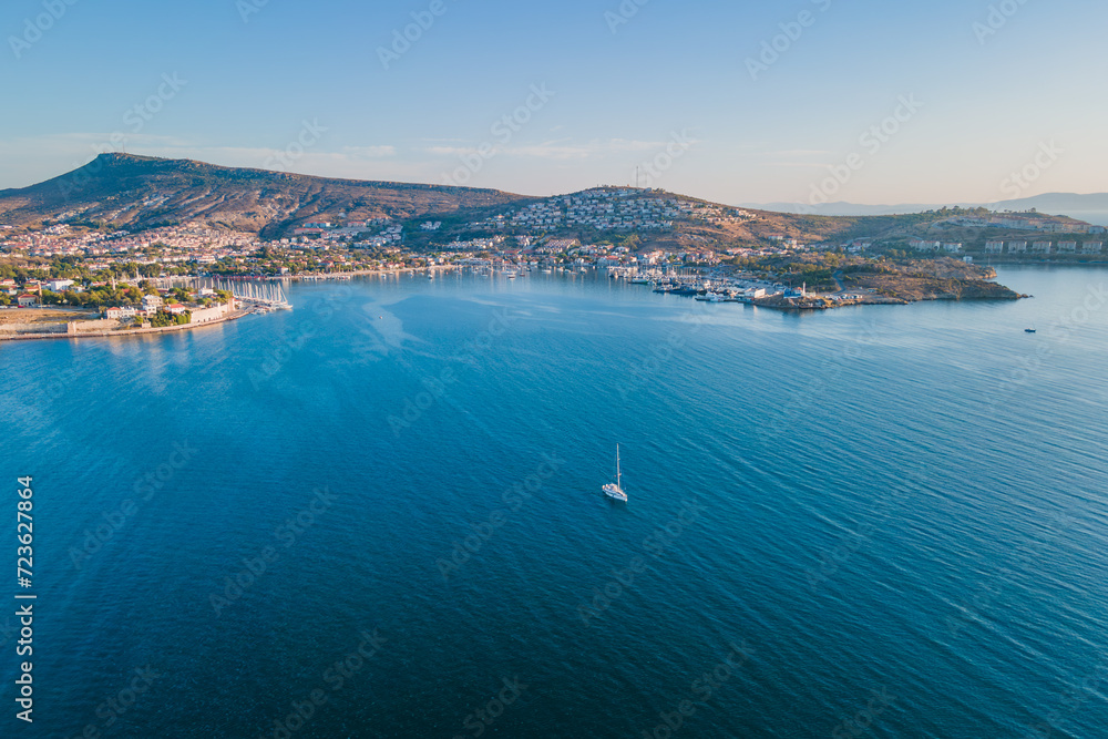 Aerial view of a yacht sailing in the sea from Foca resort town coast side on a sunny day